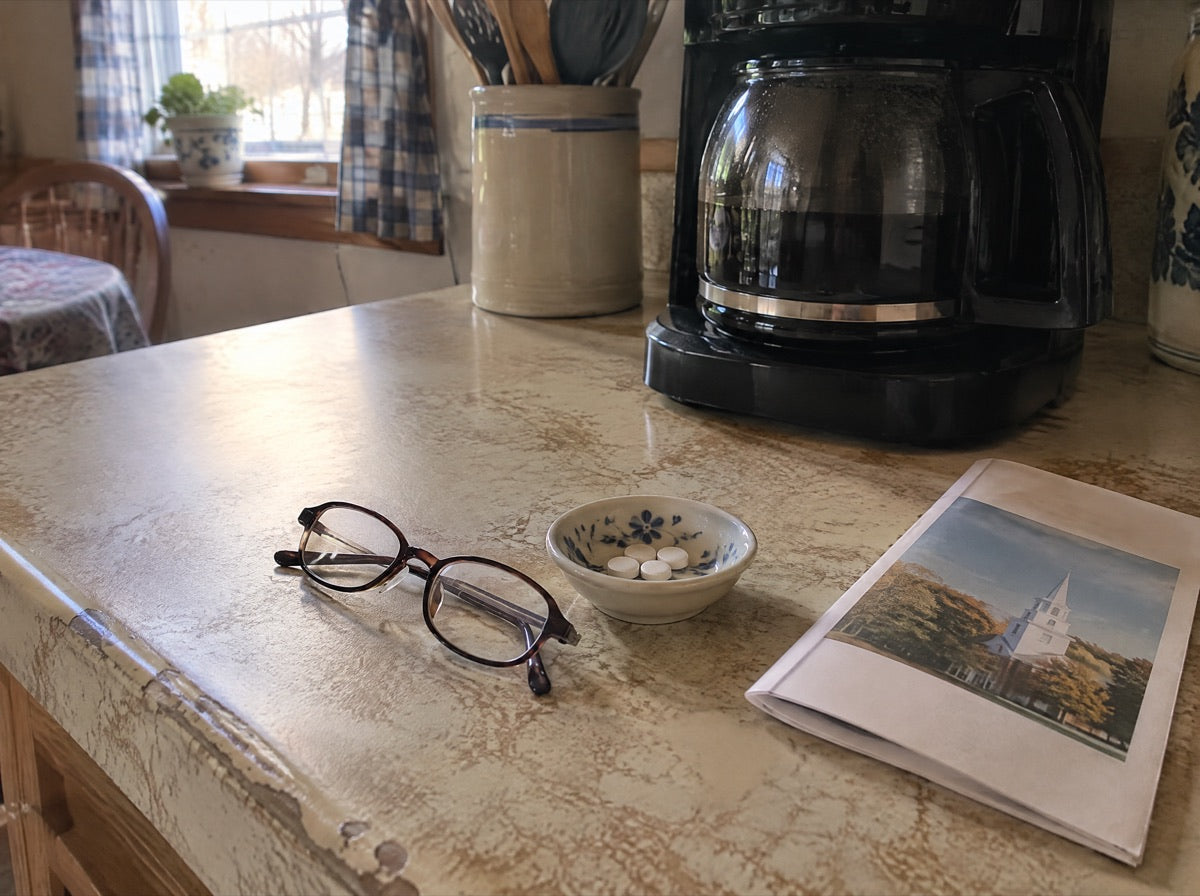 A dish of calcium pills by a coffee maker